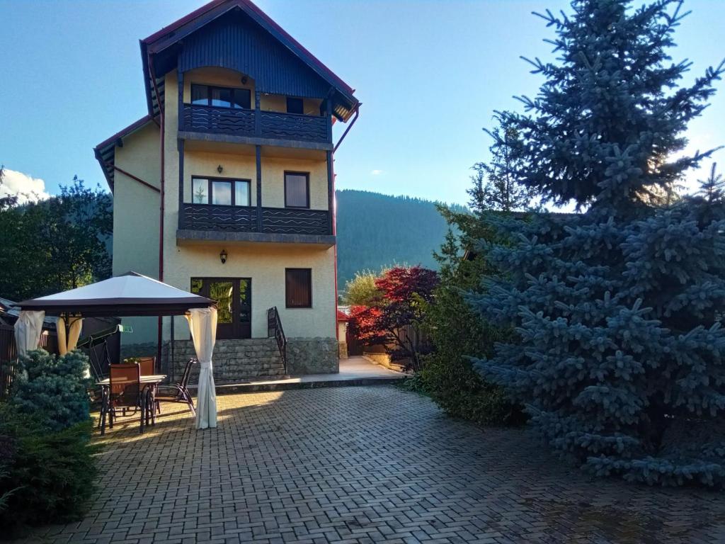 a large building with a patio and a tree at Apartament lângă Catedrală in Câmpulung Moldovenesc