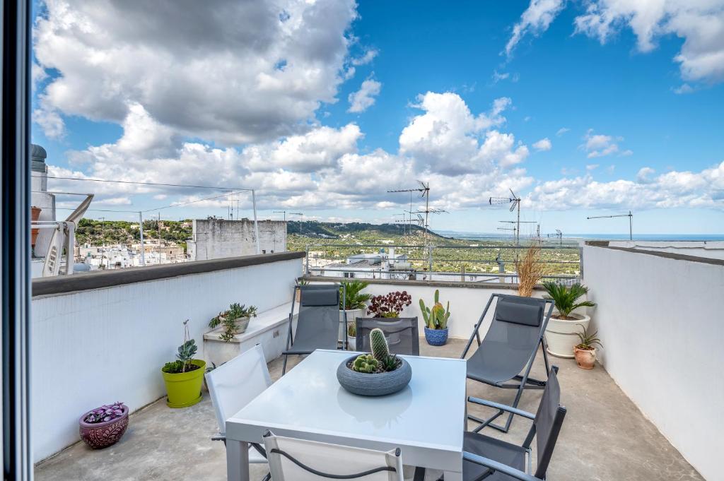 patio z białym stołem i krzesłami na balkonie w obiekcie La dimora di Sole w mieście Ostuni