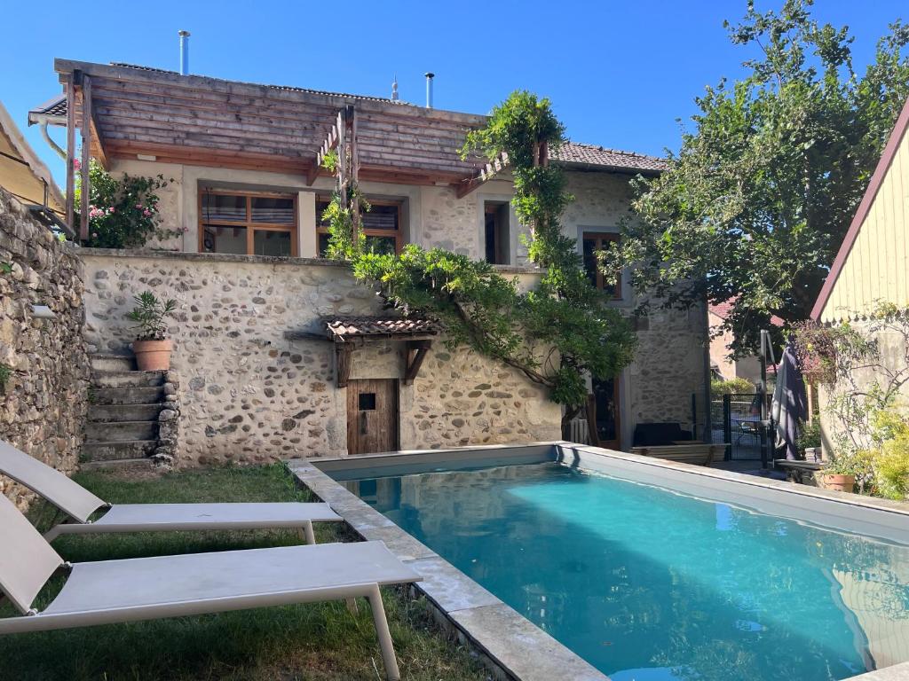 a villa with a swimming pool in front of a house at La Castanea, Charmante maison au pied du Granier in Chapareillan