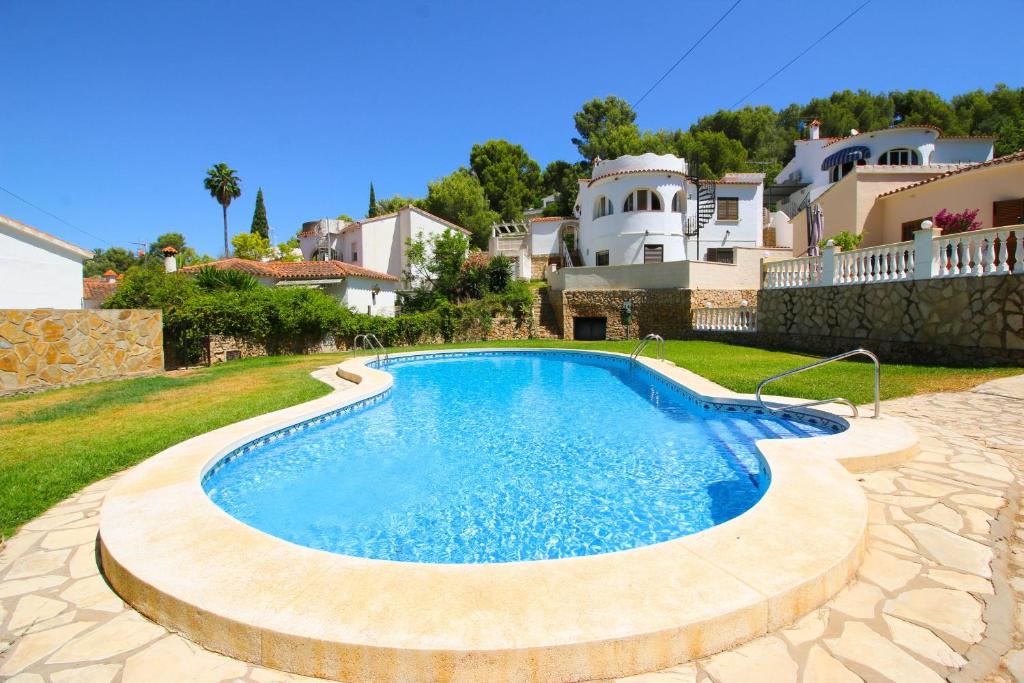 una piscina in un cortile con una casa sullo sfondo di Residencial Galeretes a Denia