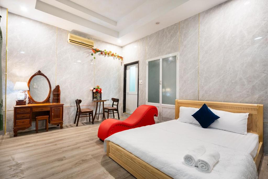 Thu Dau MotにあるKhách Sạn Tràng Anのベッドルーム1室(ベッド1台、椅子、デスク付)