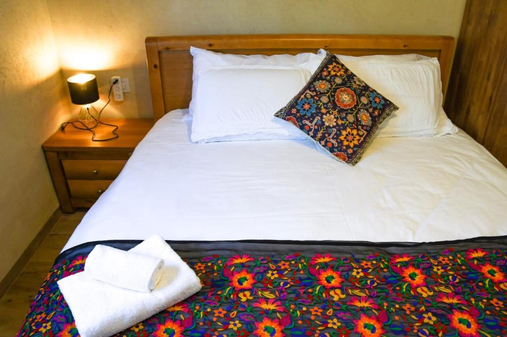 Una cama blanca con una almohada y una toalla. en לילה בחוף אכזיב en Gesher HaZiw