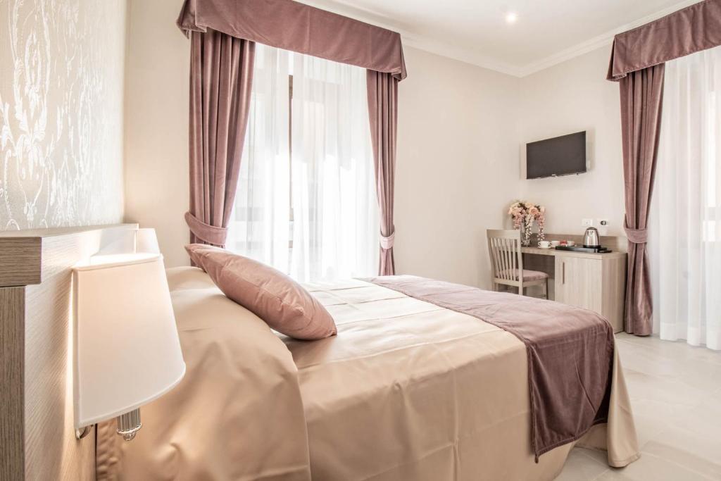 a bedroom with a bed and a table and a television at DANY GUEST HOUSE in Rome