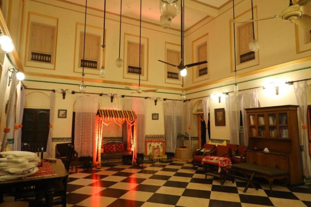 a living room with a fireplace and a checkered floor at RATNAKAR BHAWAN (HERITAGE HOMESTAY) in Varanasi