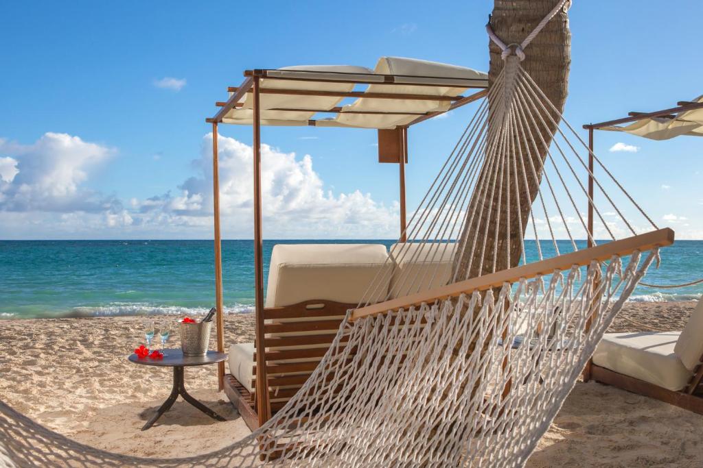 a hammock on a beach with the ocean at Impressive Premium Punta Cana - All Inclusive in Punta Cana