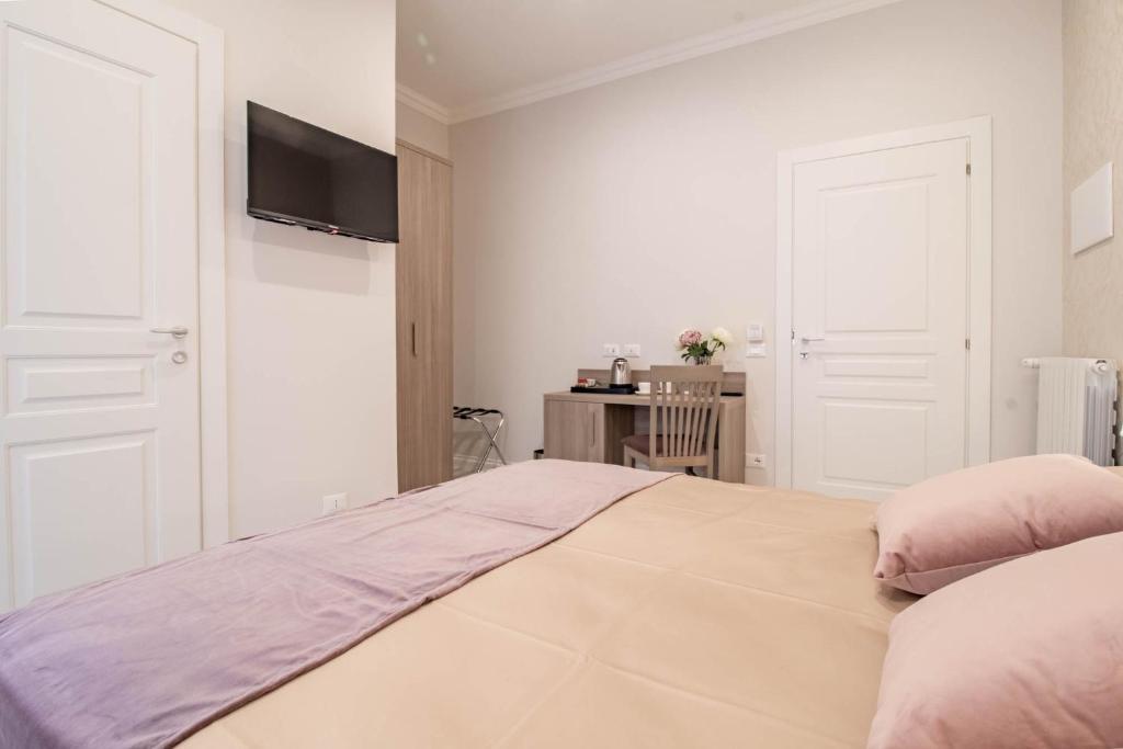 a white bedroom with a large bed with pink pillows at DANY GUEST HOUSE in Rome