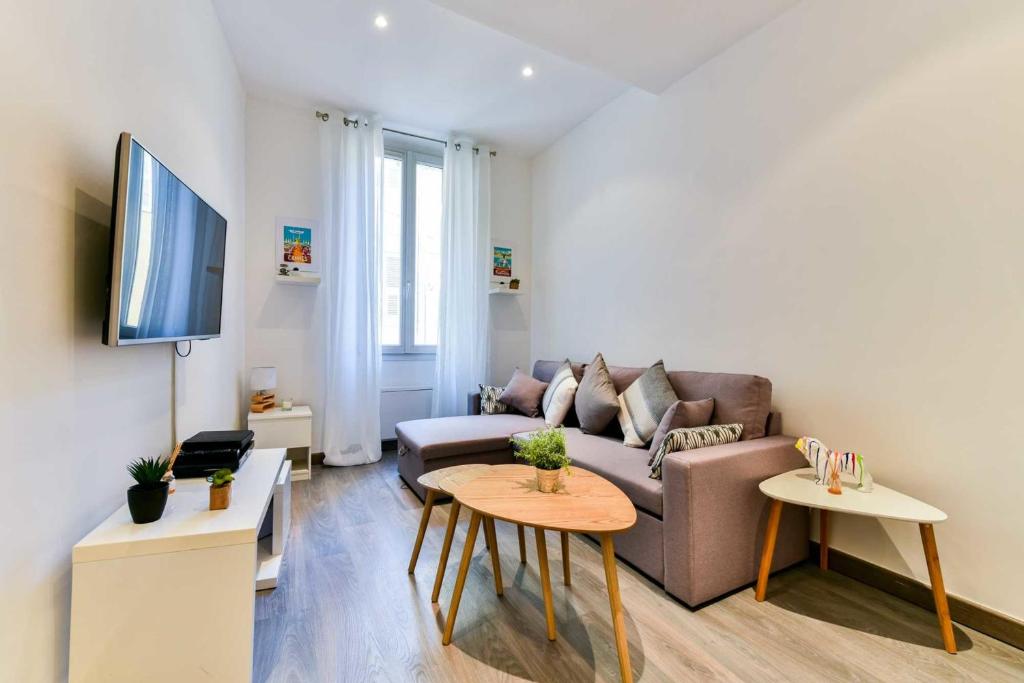 een woonkamer met een bank en een tafel bij CMG - Bel appartement - 5 min à pied du Palais des Festivals in Cannes