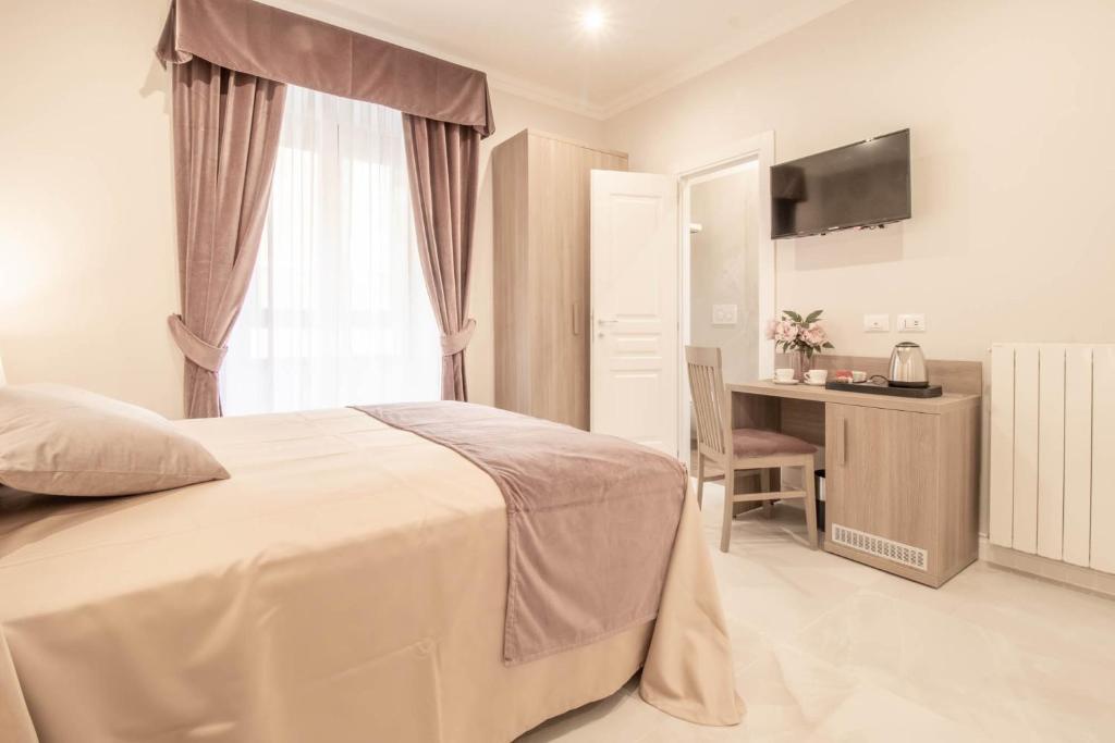 a bedroom with a bed and a desk and a television at DANY GUEST HOUSE in Rome