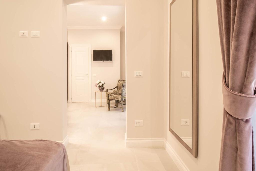 a hallway with a mirror and a room with a chair at DANY GUEST HOUSE in Rome