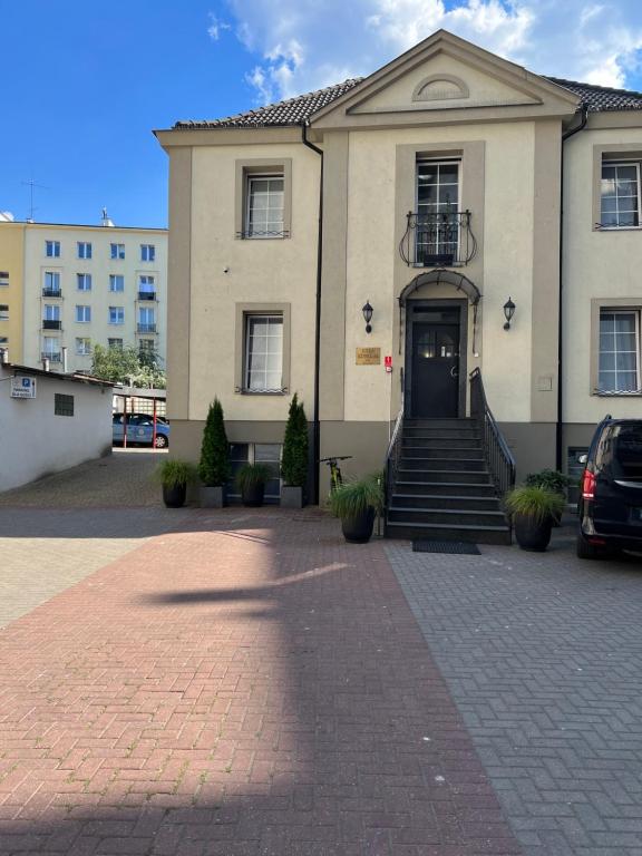 duży budynek z czarnymi drzwiami i schodami w obiekcie Villa Admiral w mieście Gdynia