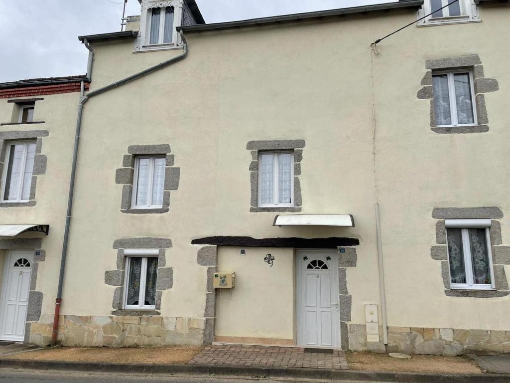 an old building with a white door and windows at GITE TREFFLE A 4 FEUILLES in Le Mayet-de-Montagne