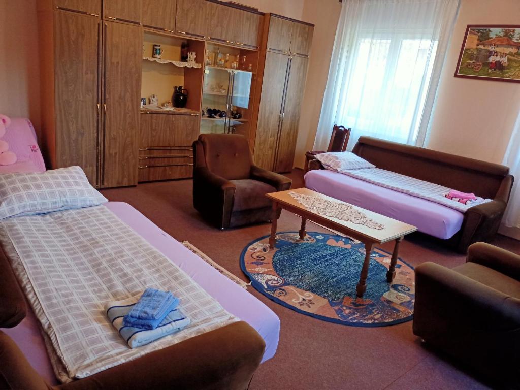 a room with two beds and a couch and a table at Kuca za odmor RADMILA - Rogljevacke pivnice in Rogljevo