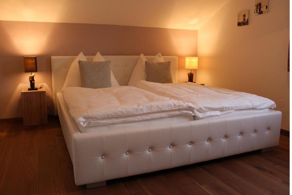 a large white bed in a room with two lamps at Haus Haslach in Elsbethen