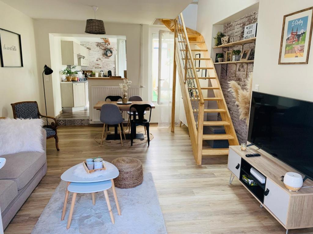 a living room with a couch and a tv at Le Cocon des Hortillonnages d'Amiens in Camon