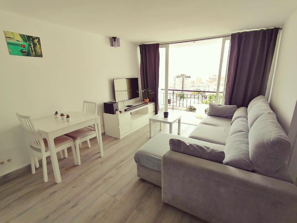 a living room with a couch and a table at BRISAMAR Apartamento con aire acondicionado in Torremolinos