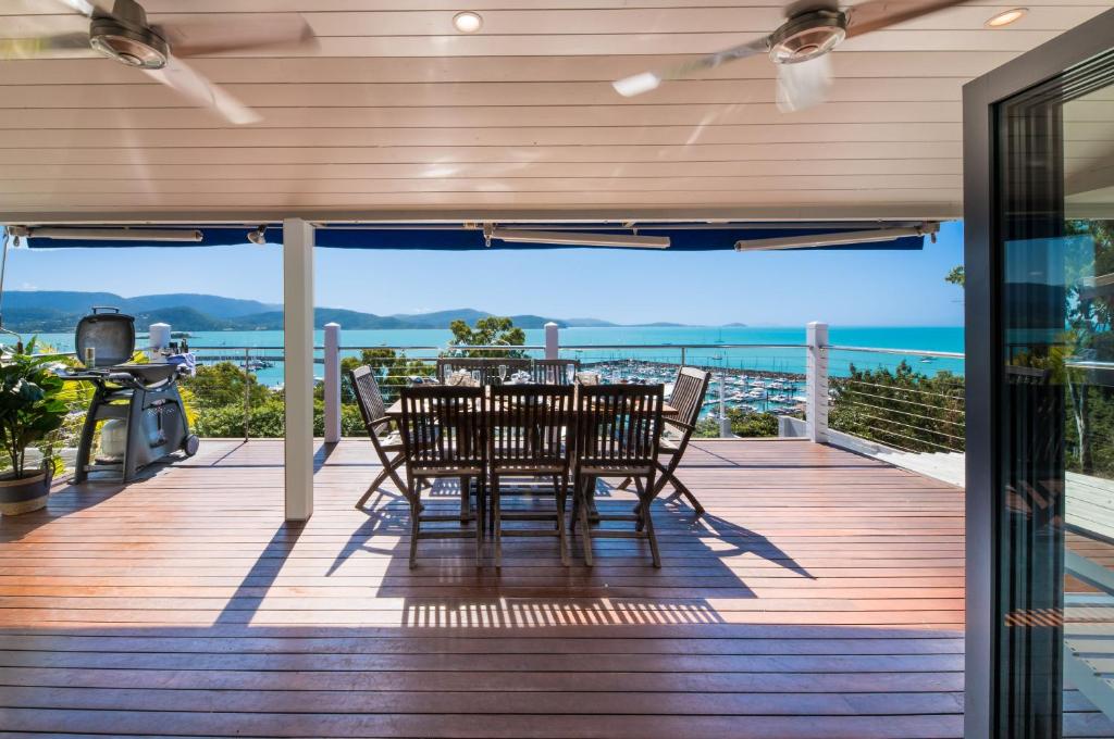 a wooden deck with a table and chairs on it at A Point of View in Airlie Beach