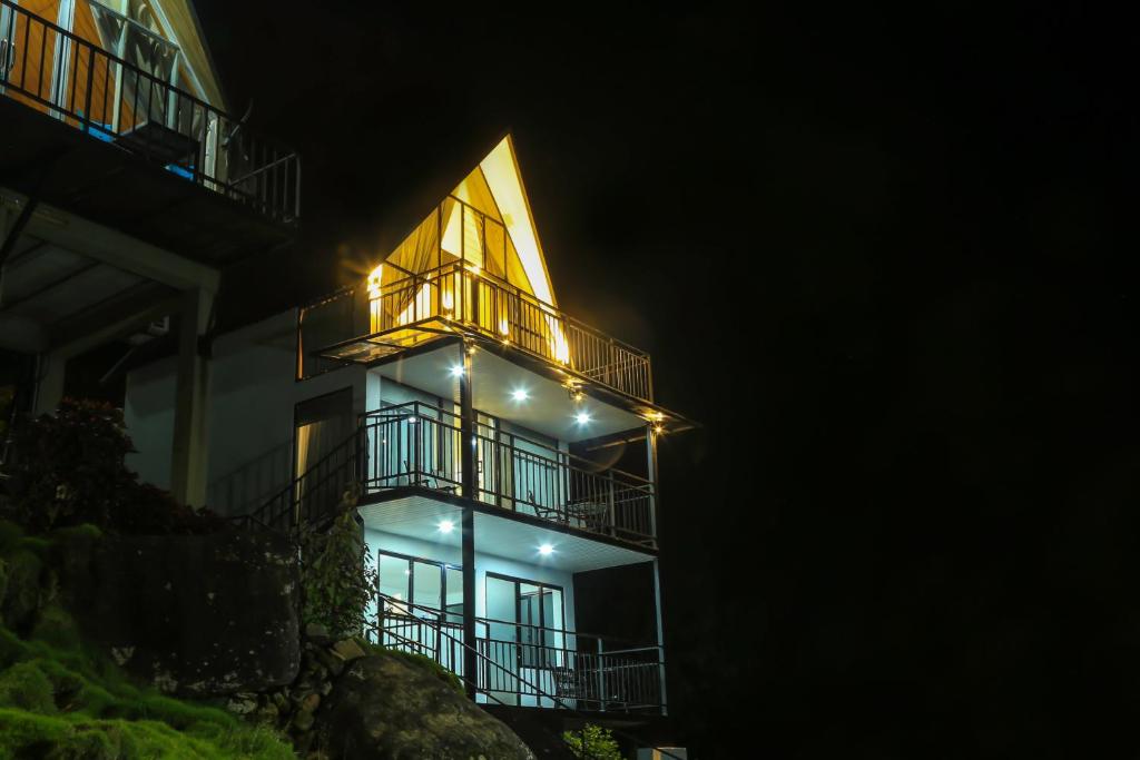 a building with lights on the side of it at night at Hummingbird St.Clare Villas in Dimbula