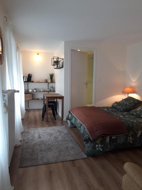 a bedroom with a bed and a table in it at Agréables chambres indépendantes - Coutances centre in Coutances