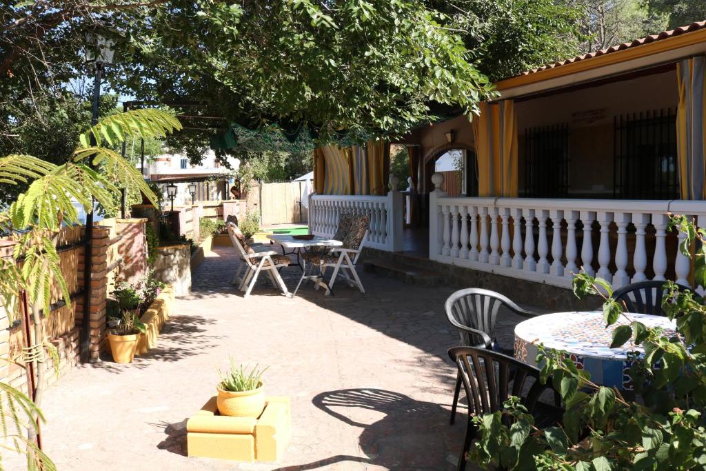 CHIBITEL Alojamiento Rural في قرطبة: فناء مع طاولة وكراسي على منزل