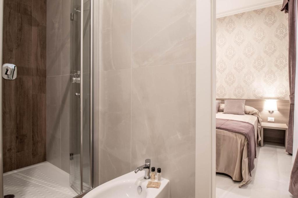 a bathroom with a shower and a sink and a bed at DANY GUEST HOUSE in Rome