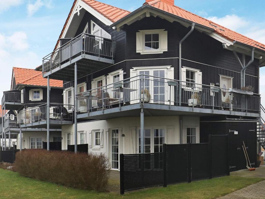 a black and white house with dogs on the balconies at 4 person holiday home in Bogense in Bogense