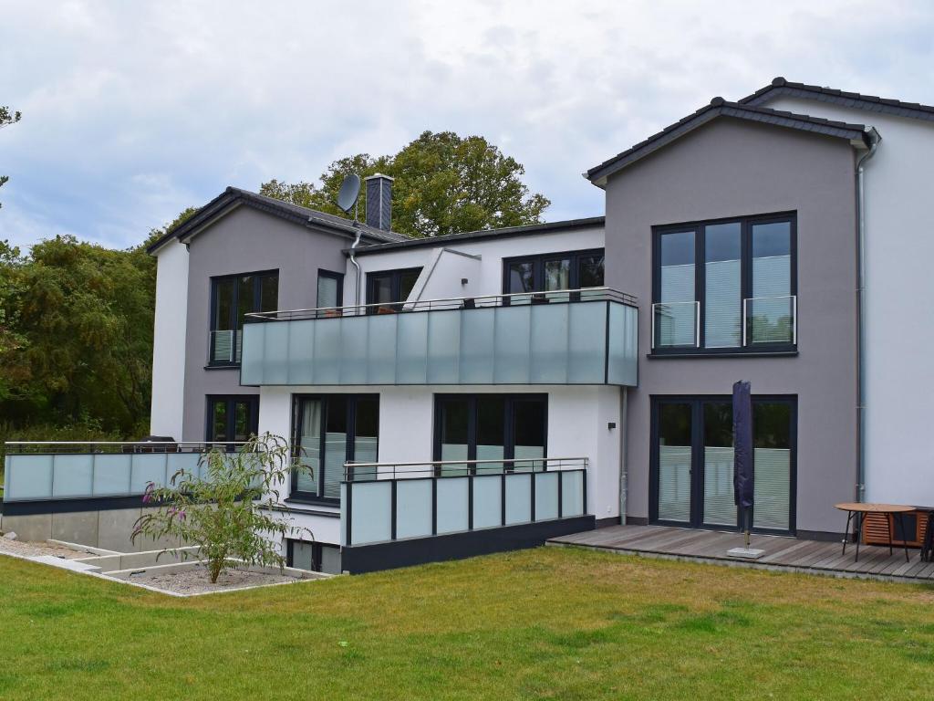 a house with a balcony and a yard at Exclusive apartment on Fehmarn in Petersdorf auf Fehmarn