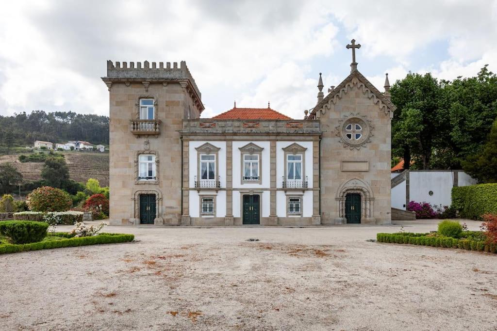 un vieux bâtiment avec une horloge à l'avant dans l'établissement Casa de Sequeiros, à Baião