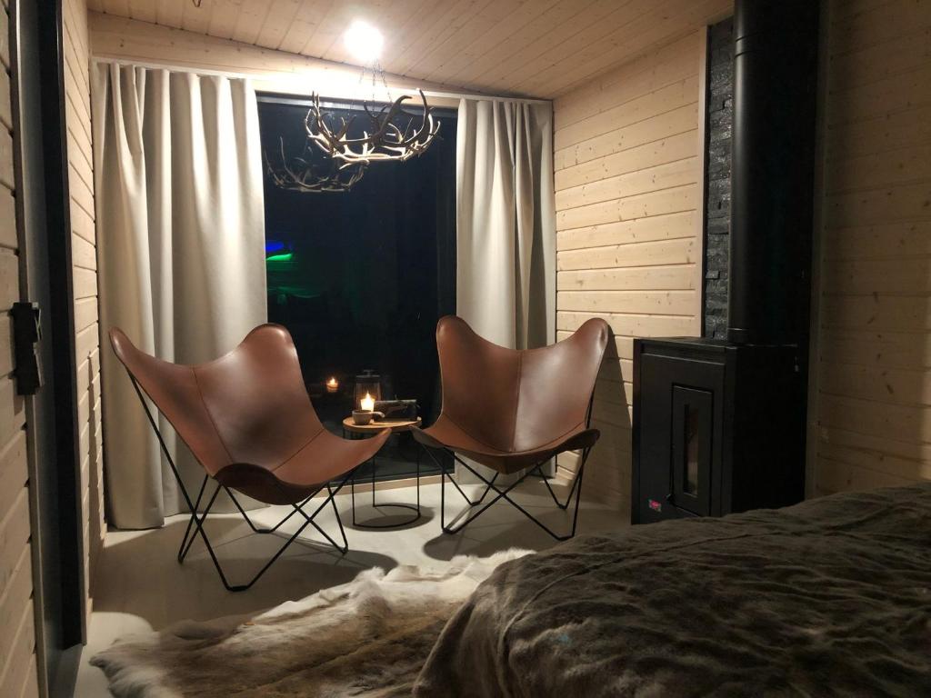 um quarto com 2 cadeiras, uma mesa e uma cama em Skyfire Village Igloos em Rovaniemi