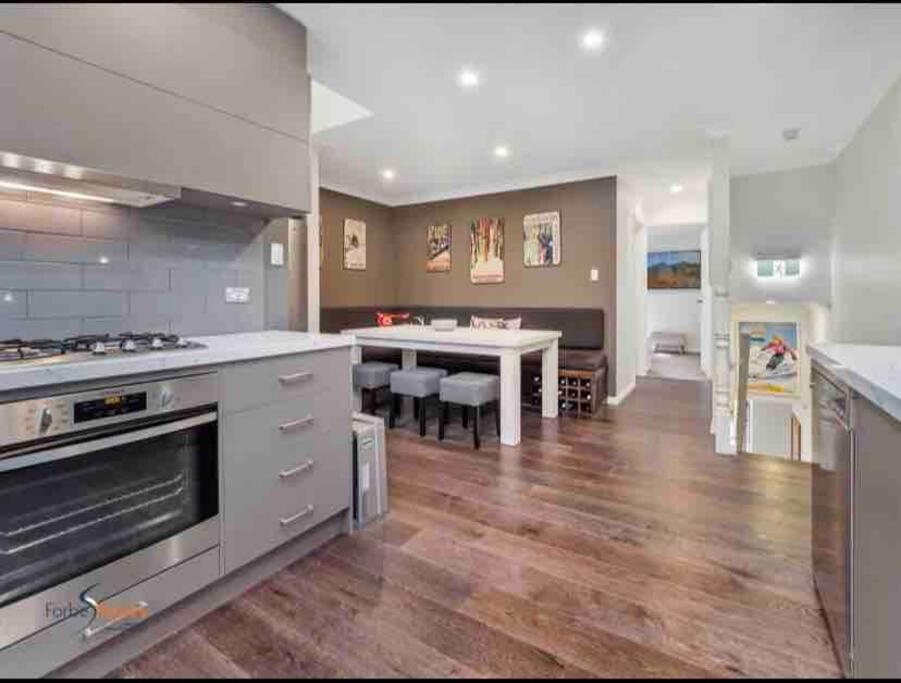 a large kitchen with a table and a dining room at Stylish Thredbo Alpine Chalet + Garage in Tranquil Setting in Thredbo