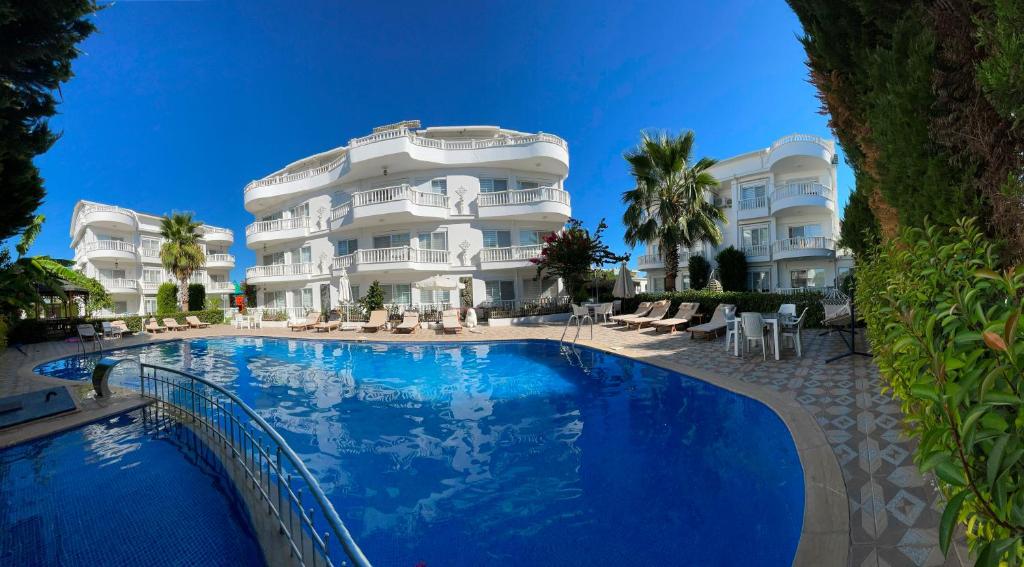 un hôtel avec une piscine en face d'un bâtiment dans l'établissement Belka Golf Residence Exclusive Apt Poolside, à Belek