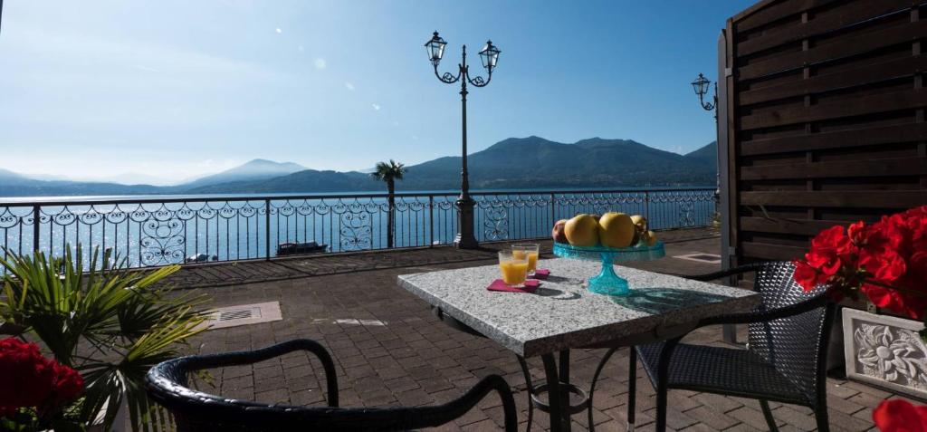a table and chairs on a balcony with a view at Studio 2- lake view in Oggebbio