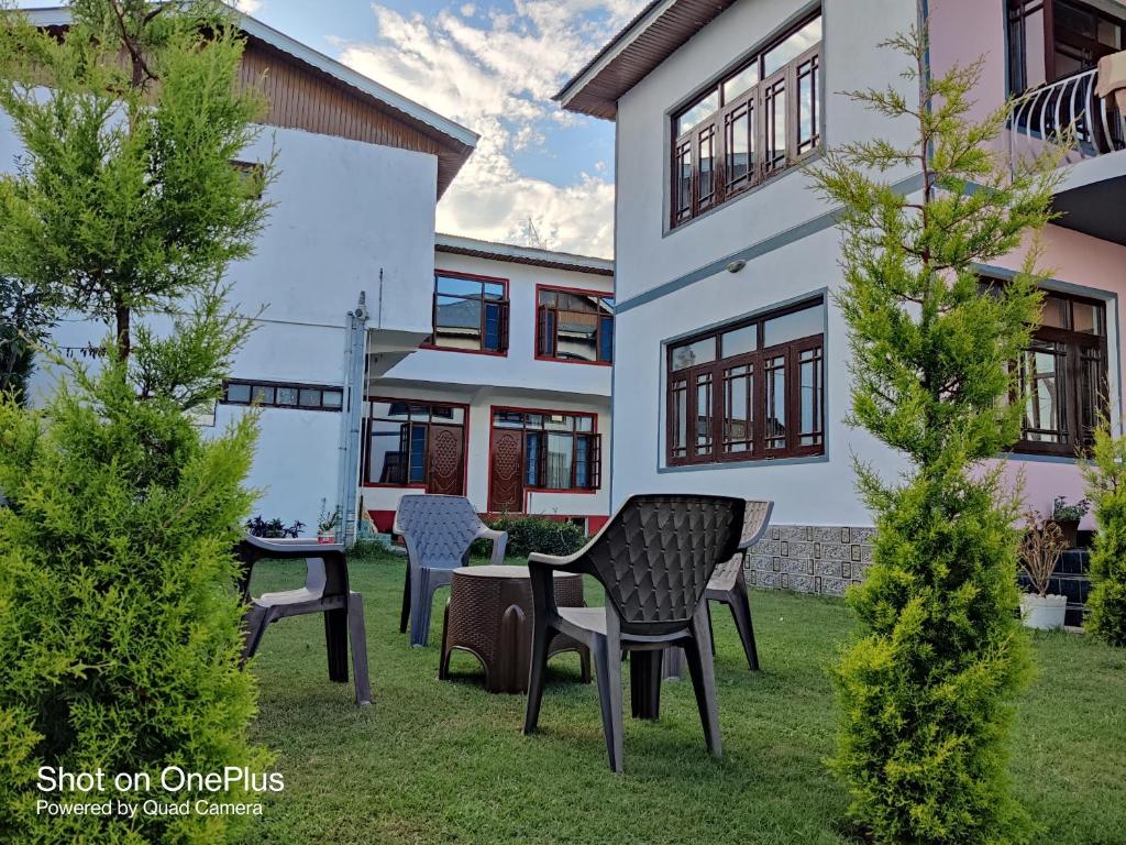 een huis met twee stoelen en een tafel in de tuin bij Kashmir Homestay in Gulmarg