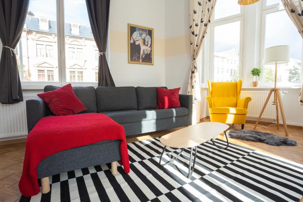 ein Wohnzimmer mit einem Sofa und einem Stuhl in der Unterkunft FULL HOUSE Premium Apartments - Halle Paulusviertel in Halle an der Saale