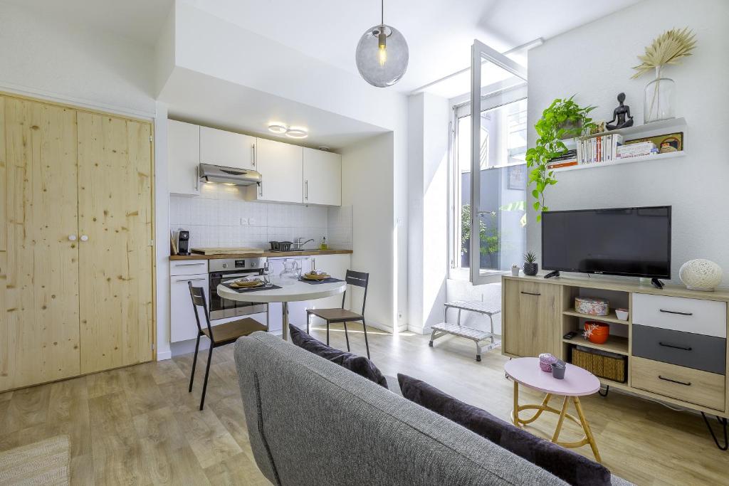 a living room with a couch and a table at Superbe F1 avec terrasse et parking privé in Évian-les-Bains