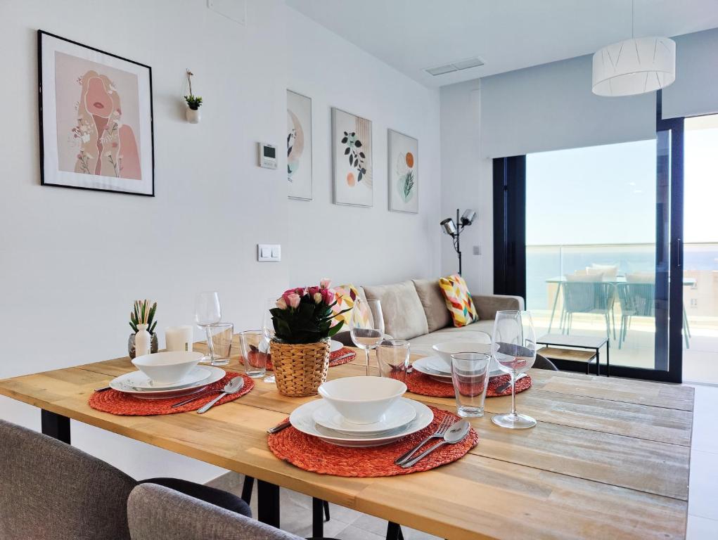 tavolo da pranzo con piatti e bicchieri di SUNSET CLIFFS sea view apartments a Benidorm