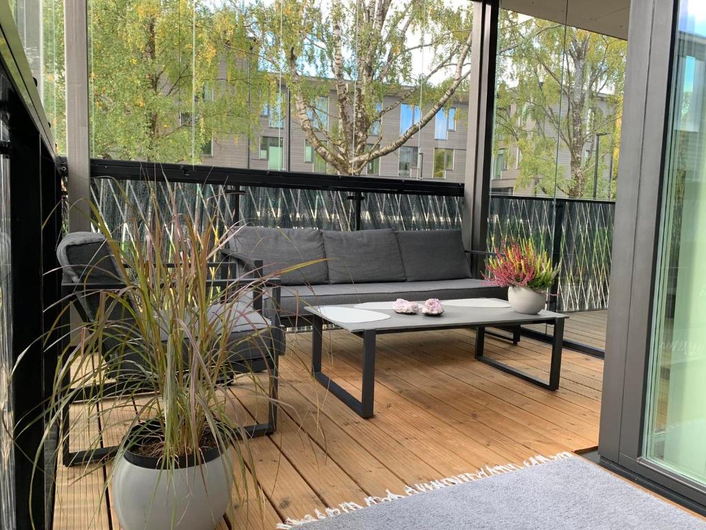 d'une terrasse avec un canapé et une table sur un balcon. dans l'établissement ÖÖ Street Premium Apartment with Terrace, à Tartu