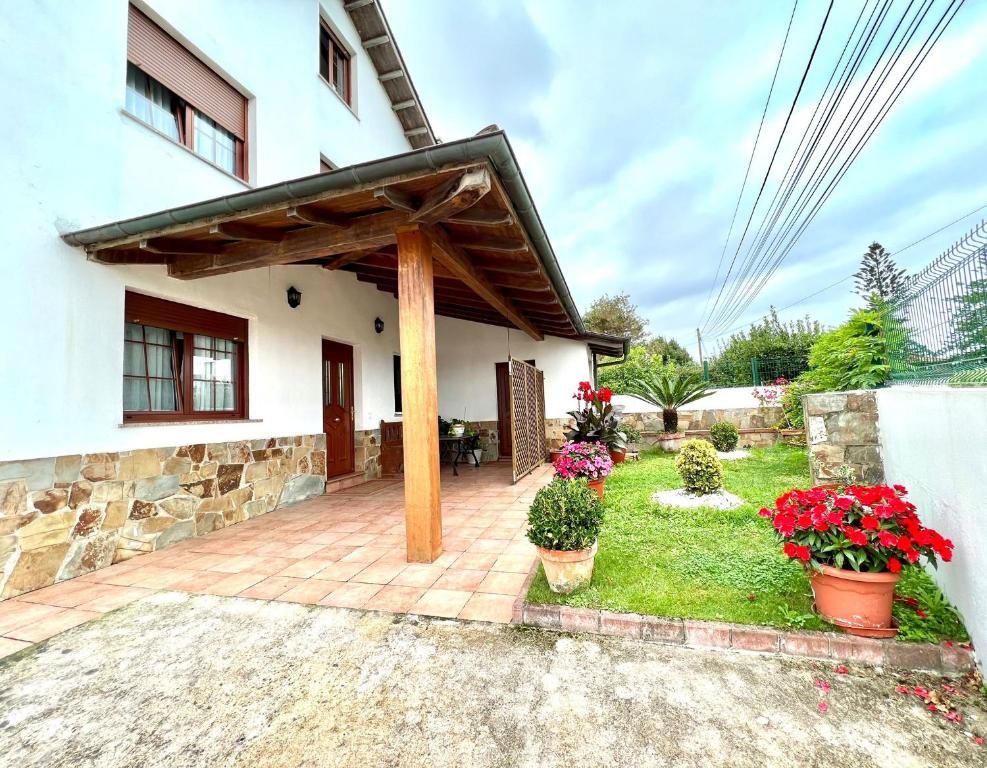 a house with a patio with flowers in a yard at Cozy apartment, FreeWifi, nearby beach in Cadavedo in Cadavedo