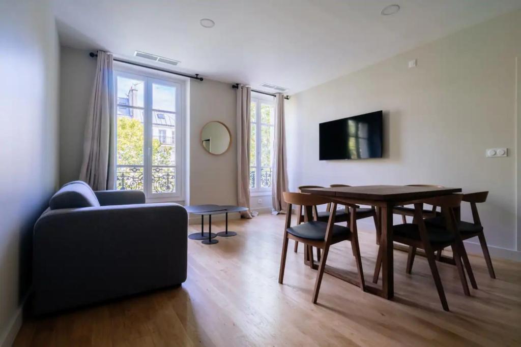 salon ze stołem i kanapą w obiekcie Stylish 2 Bedroom Apartment in Paris w Paryżu
