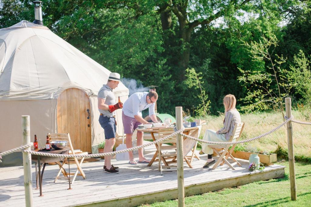 a group of people standing around a tent at Yurtshire Fountains - Wensley Yurt in Ripon