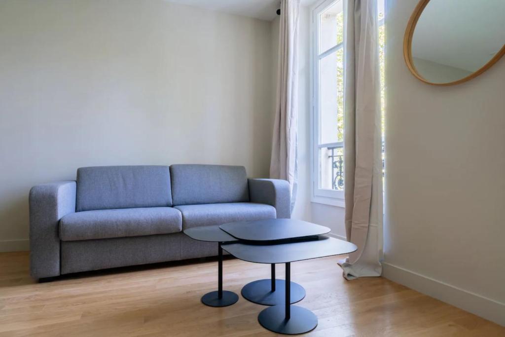 salon z niebieską kanapą i stołem w obiekcie Stylish 2 Bedroom Apartment in Paris w Paryżu