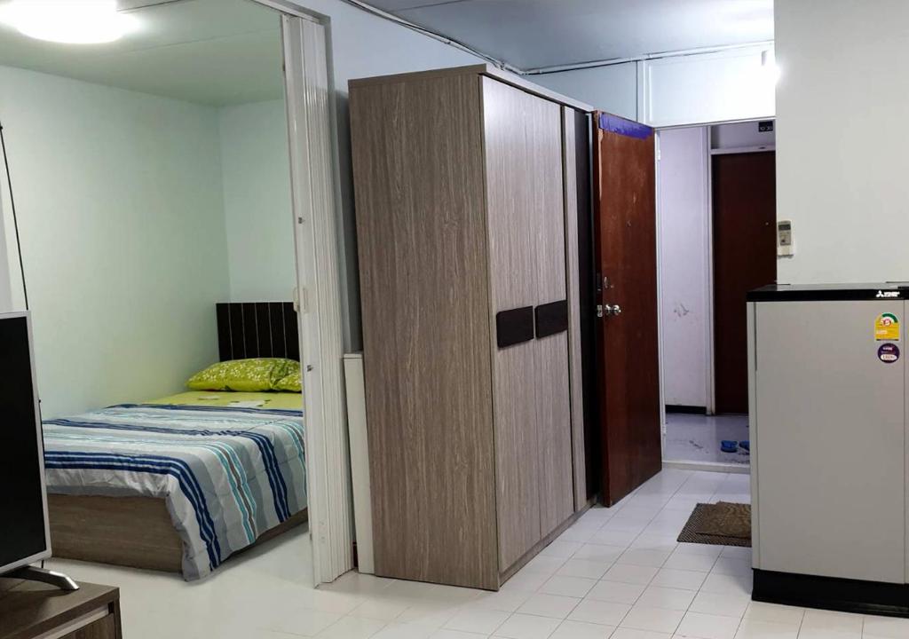 een slaapkamer met een bed en een schuifdeur bij ห้องใหญ่-ห้องพักรายวัน เมืองทองธานี เรือนศรีตรัง in Nonthaburi
