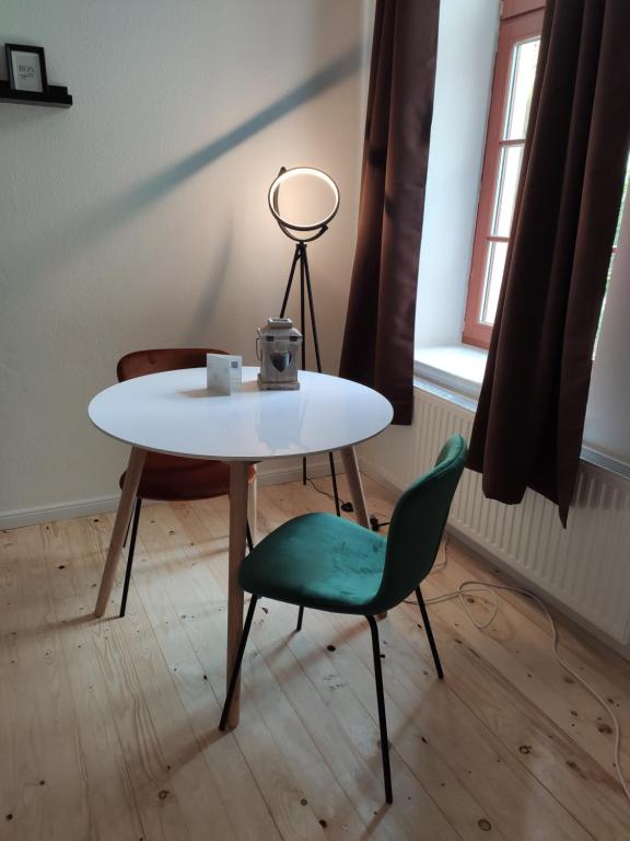 un tavolo e una sedia in una stanza con un tavolo di Altstadt Lübsche Straße a Wismar