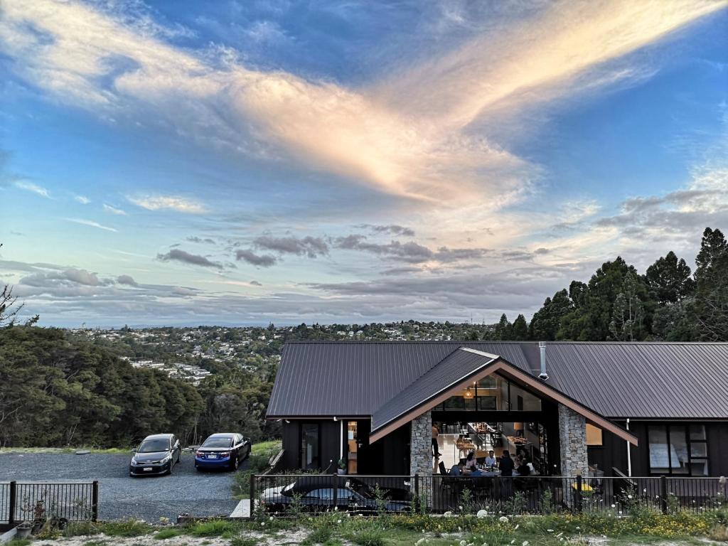 dois carros estacionados num parque de estacionamento ao lado de uma casa em Echo Lodge em Auckland