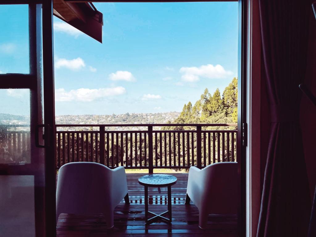 a view of a balcony with a table and chairs at Echo Lodge in Auckland