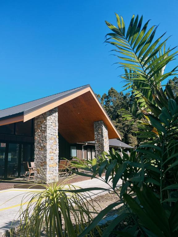a house with a stone and wood at Echo Lodge in Auckland