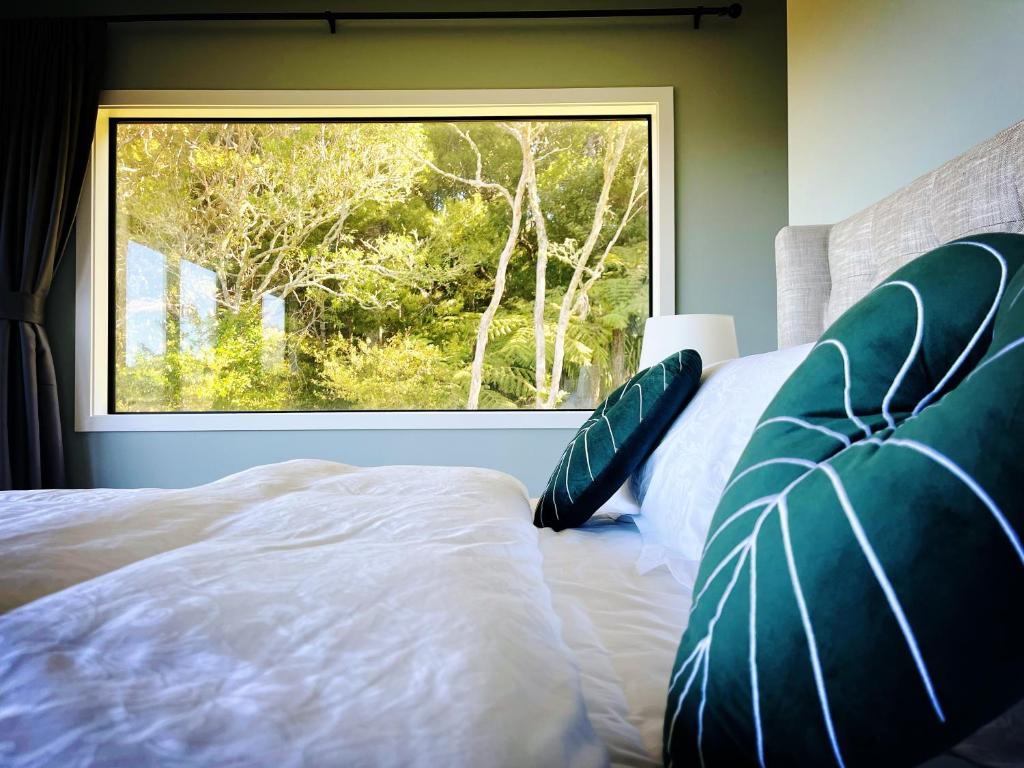 a bedroom with a bed and a large window at Echo Lodge in Auckland