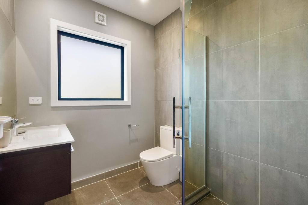 a bathroom with a toilet and a glass shower at Echo Lodge in Auckland