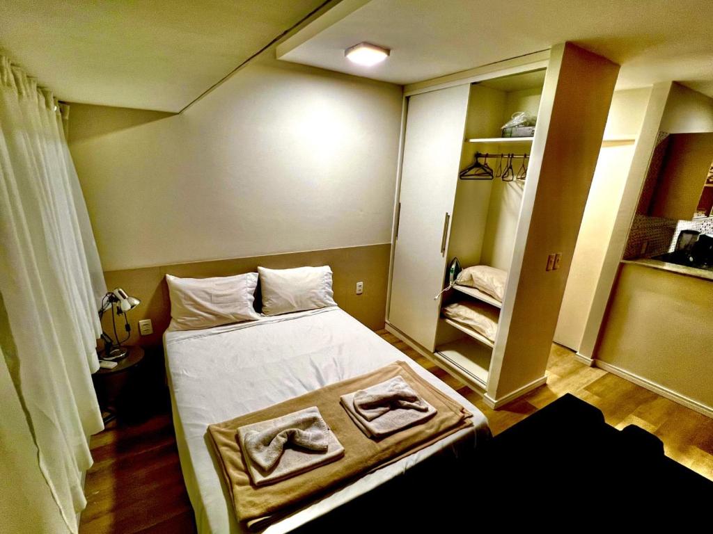 a small room with a bed and a closet at Flat Boa Viagem luxo in Recife