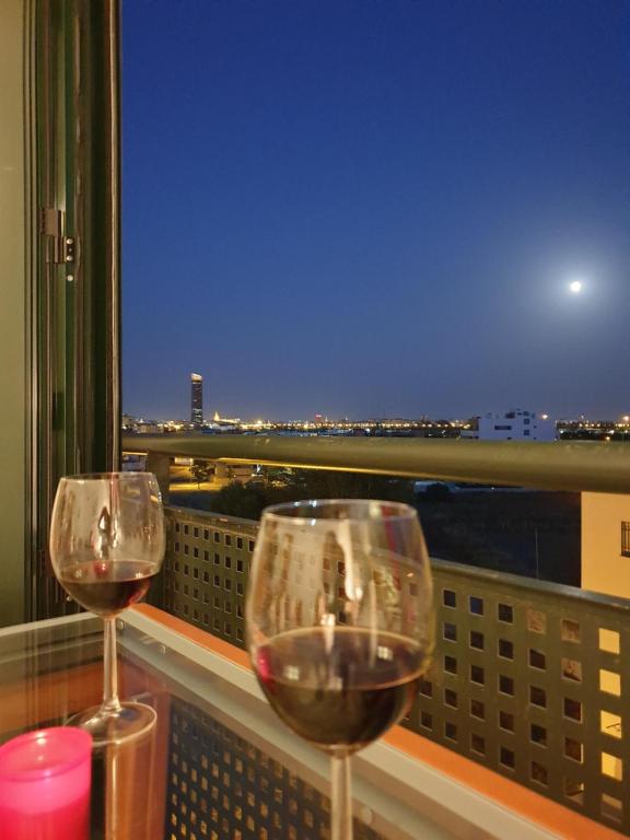 two glasses of wine sitting on a balcony with a view at Platea de Sevilla in Seville