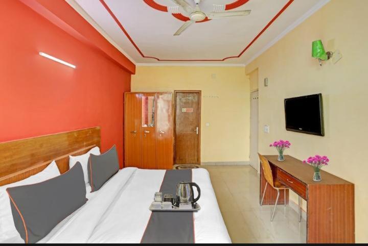 een kamer met een bed en een televisie en afkeer bij Hotel Ashvins Palace in Gurgaon